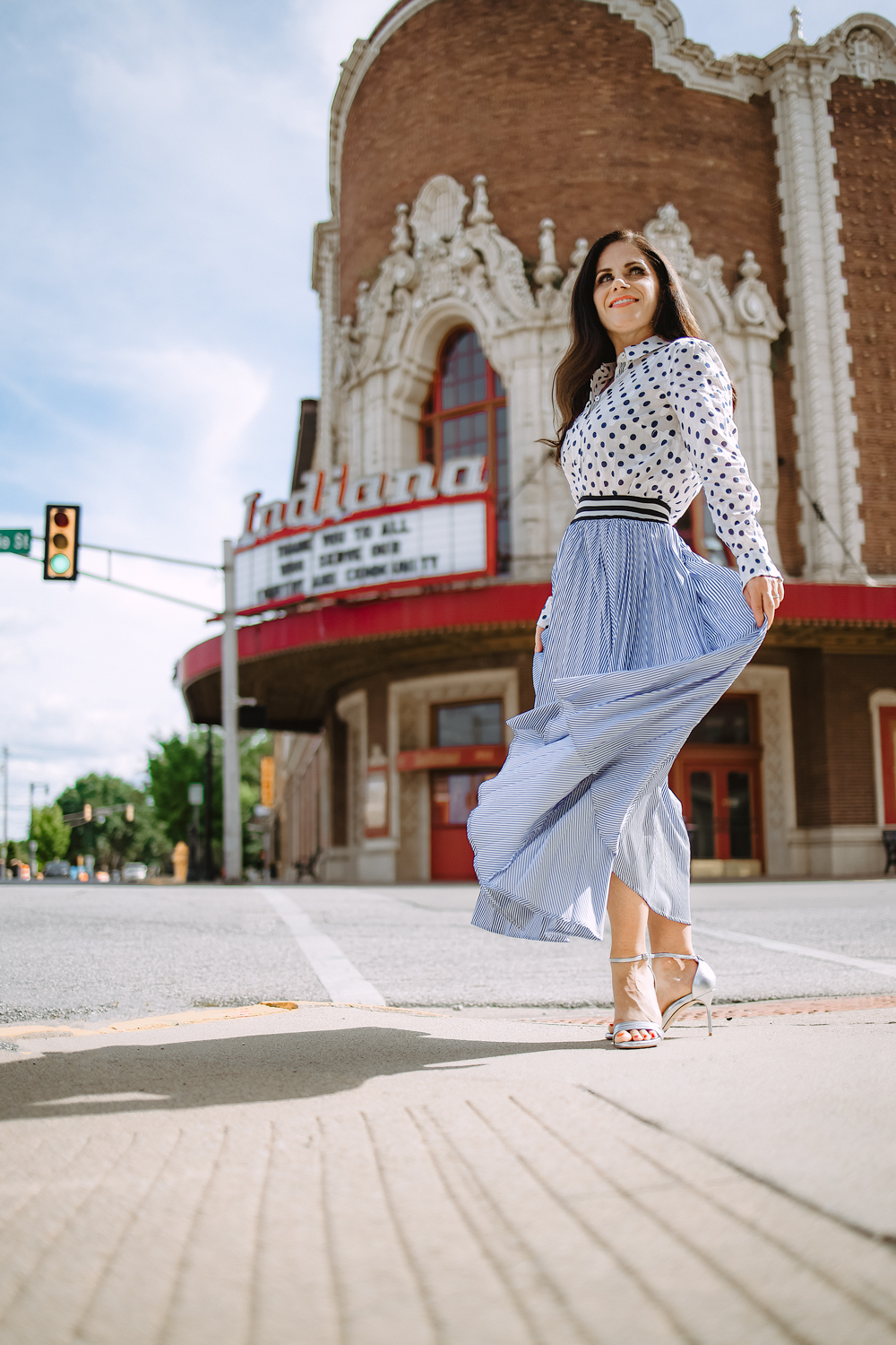 woman swishing skirt in front of historic theater